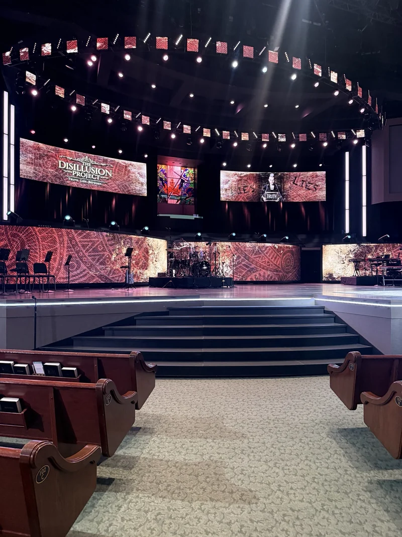 Prestonwood stage prepared for The Disillusion Project, screens lit above empty pews